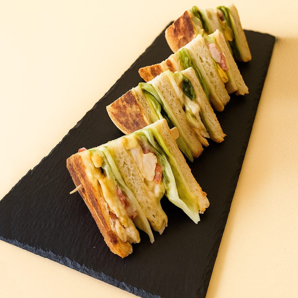 Club sandwich quarters lined up on slate